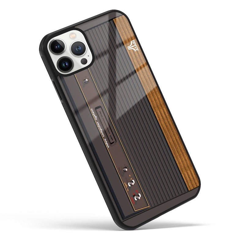 May include: A black phone case with a retro video game console design. The case has a woodgrain pattern on the side and the text "video audio watch's television" on the front.