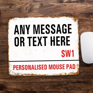 May include: White personalised mouse pad with a distressed metal look. The text "ANY MESSAGE OR TEXT HERE SW1 PERSONALISED MOUSE PAD" is printed in black and red.