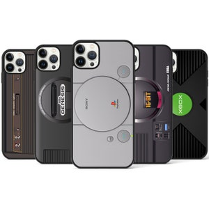 May include: Five different phone cases featuring retro video game console designs. The cases are black, grey, and green with the logos for Sega Genesis, Playstation, Sega Mega Drive, and Xbox.
