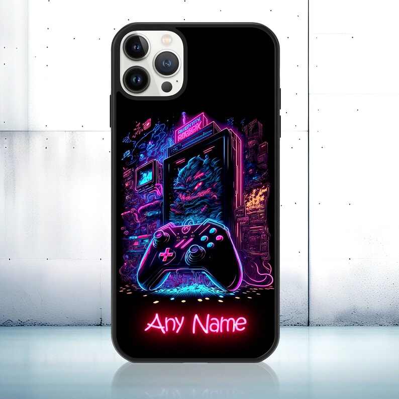 Op de afbeelding: Een zwarte telefoonhoes met een neonroze en blauwe print met een retro videogameconsole, een joystick en de tekst "Any Name".