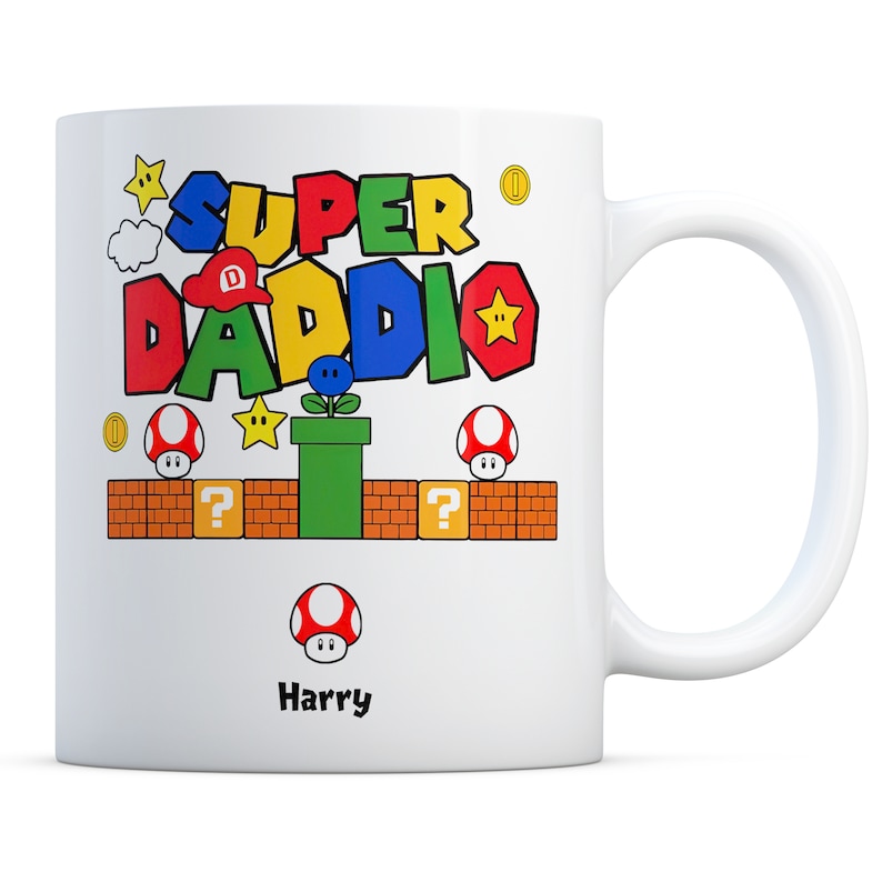May include: White ceramic mug with a colorful Super Daddi design featuring a Mario-themed graphic with a mushroom, question mark block, and a pipe. The name Harry is printed below the graphic.