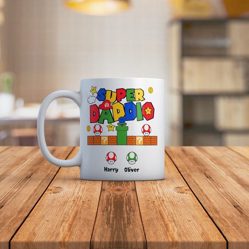 May include: White ceramic mug with a Super Daddi design featuring a Mario-themed graphic with a green pipe, question blocks, and coins. The text "Harry Oliver" is printed below the graphic.