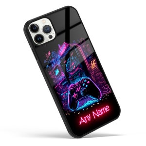 Op de afbeelding: Een zwarte telefoonhoes met een neonroze en blauw ontwerp met een videogamecontroller en een retro arcade-spel. De tekst "Any Name" staat in neonroze onderaan de hoes.
