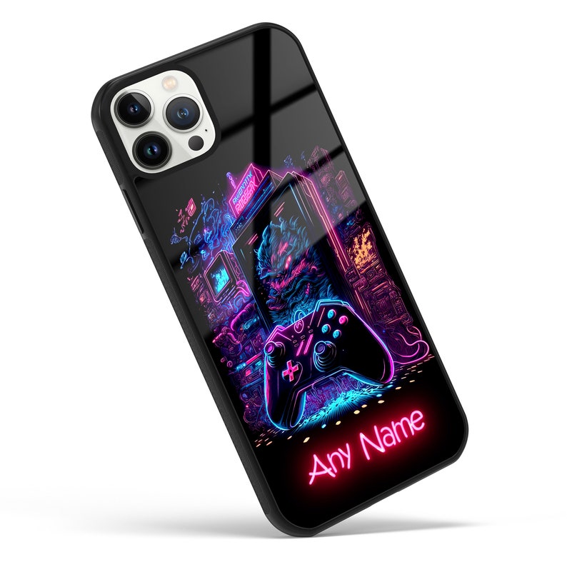 Op de afbeelding: Een zwarte telefoonhoes met een neonroze en blauw ontwerp met een videogamecontroller en een retro arcade-spel. De tekst "Any Name" staat in neonroze onderaan de hoes.