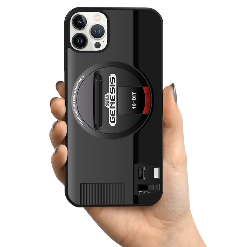 May include: Black phone case with a Sega Genesis 16-bit video game console design. The case has a black and red color scheme and features the Sega Genesis logo and the words "High Definition Graphics".