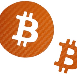 Può includere: Due simboli Bitcoin arancioni e bianchi. Il simbolo più grande è un cerchio con una trama in fibra di carbonio. Il simbolo più piccolo è un semplice contorno.