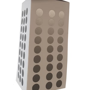 Op de afbeelding: Een beige kartonnen doos met een geometrisch patroon van zwarte cirkels. De cirkels zijn gerangschikt in drie verticale rijen, waarbij de cirkels in elke rij geleidelijk in grootte toenemen van boven naar beneden.