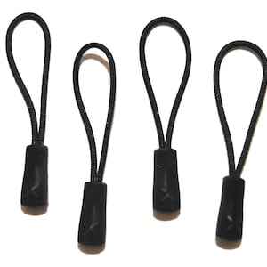 Puede incluir: Cuatro tiradores de cremallera negros con un pequeño diseño en 'X' en la parte inferior.