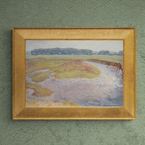 May include: A framed landscape painting depicting a river meandering through a field with green trees in the background. The painting is hung on a green wall above a desk with a computer, a white vase, and a magazine.