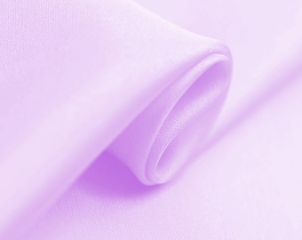 May include: A close-up of a soft, light purple fabric with a smooth, silky texture. The fabric is folded and draped, creating a flowing, elegant look.