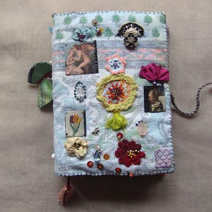 un diario di medie dimensioni con copertina morbida fatto a mano, carta con motivi, mappe, foto, tasche per l'auto-progettazione, molte pagine