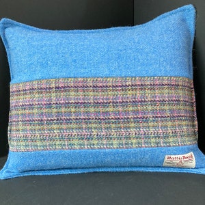 Puede incluir: Cojín de tiro azul y rayado multicolor con una etiqueta de Harris Tweed.