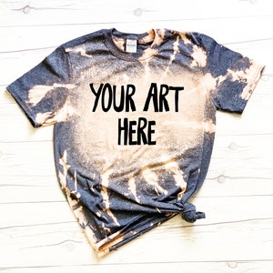May include: A dark gray t-shirt with a bleach-splattered design. The shirt has the text "YOUR ART HERE" printed in black.