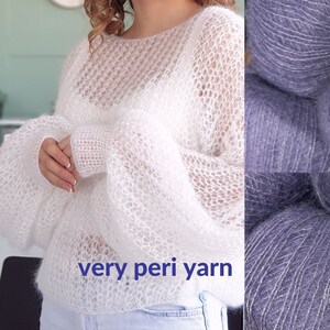 May include: A white, lightweight, open knit sweater made with very peri yarn. The yarn is also shown in a purple color.