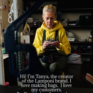 May include: A woman in a yellow hoodie and apron working on a leather bag. The image includes text that reads, "Hi! I'm Tanya, the creator of the Lamponi brand. I love making bags. I love my customers. Every piece I create is made with care and attention."