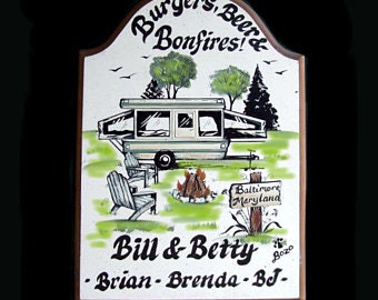 May include: A wooden sign with a hand-painted illustration of a camper, two chairs, and a campfire. The sign reads "Burgers, Beer, Bonfires!" and "Bill & Betty - Brian - Brenda - BJ -" with a small sign that says "Baltimore Maryland".
