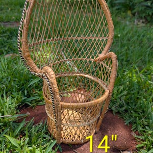 May include: A small, woven wicker peacock chair with a rounded back and armrests. The chair is made of light brown wicker and has a diamond pattern. The chair is 14 inches tall.