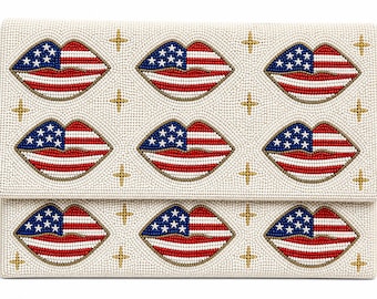 May include: A white beaded clutch featuring a pattern of red, white, and blue lips, each with a design resembling the American flag. Gold star accents are scattered across the surface, creating a patriotic theme.