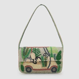 Op de afbeelding: Beaded schoudertas met een golfkarretje. De tas heeft een beige basis met een golfkarretje en groen gebladerte. De band en randen zijn lichtgroen. De rechthoekige tas heeft een klepsluiting.