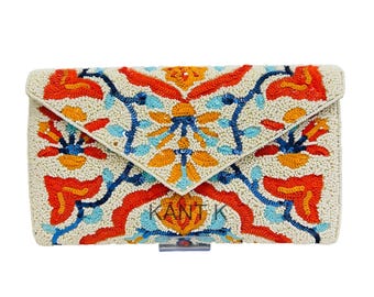 May include: Ivory-colored beaded clutch with a flap closure. The clutch features a vibrant floral pattern in orange, blue, and yellow. The text "KANT K" is visible on the front. The clutch has a silver-tone clasp.