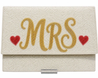 May include: Ivory beaded clutch with the word "MRS" in gold script, flanked by two red heart accents. The clutch has a rectangular shape with a fold-over flap and a silver clasp. A stylish accessory for a wedding or special occasion.