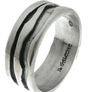 Op de afbeelding: Een zilveren ring met een textuurontwerp met drie parallelle, golvende lijnen. De ring heeft een licht geoxideerde afwerking en de inscriptie "IL GALCONE" is zichtbaar aan de binnenkant. Een uniek sieraad.