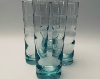 May include: Set of four turquoise blue glass drinking glasses with a textured design.