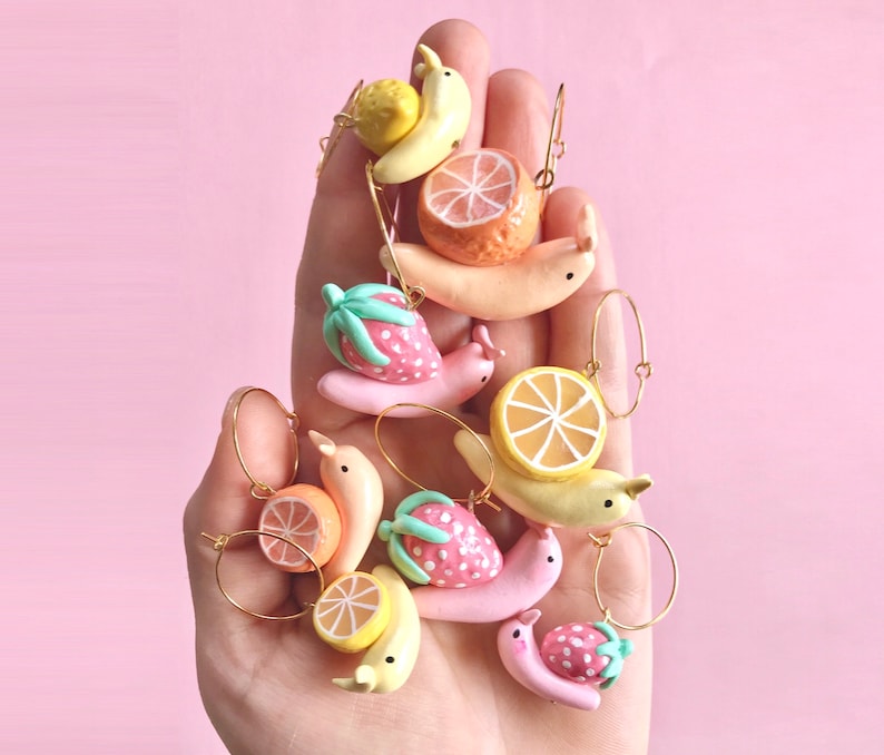 Pu&ograve; includere: Una collezione di orecchini a forma di lumaca colorati con accenti di frutta. Gli orecchini presentano una variet&agrave; di frutti, tra cui fragole, arance e banane. Le lumache sono realizzate in pasta polimerica e sono dipinte in colori vivaci. Gli orecchini sono perfetti per aggiungere un tocco di fantasia a qualsiasi outfit.