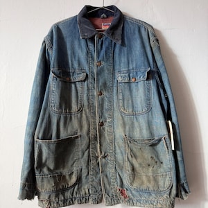 May include: Vintage blue denim work jacket with a corduroy collar, four front pockets, and button closures. The jacket shows signs of wear and tear, with faded areas and some distressing.