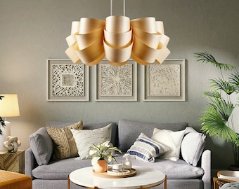 May include: A light-colored wooden pendant light fixture featuring multiple curved, ribbon-like slats arranged in a circular, layered pattern. The fixture is suspended by two thin white cords from the ceiling, creating a sculptural, organic form.