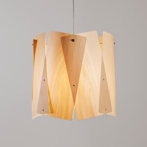 May include: A modern pendant light fixture made of wood with a geometric design. The light is made of multiple pieces of wood that are joined together to create a unique and stylish look.