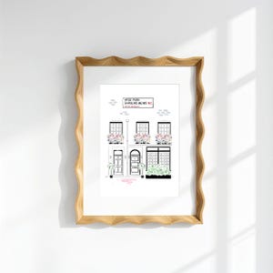 Pu&ograve; includere: Una stampa artistica incorniciata che mostra un disegno al tratto di una casa mews londinese con infissi neri, fioriere rosa e un cartello con la scritta Hyde Park Gardens Mews W2. La cornice &egrave; in legno chiaro con un bordo ondulato.