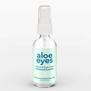 Puede incluir: Un frasco pulverizador de vidrio transparente con boquilla blanca y etiqueta verde menta claro. La etiqueta muestra el texto azul "aloe eyes", "natural eye care", "cleanses & hydrates", "Fractionally Distilled Aloe Vera" y "2 fl oz | 60 ml".