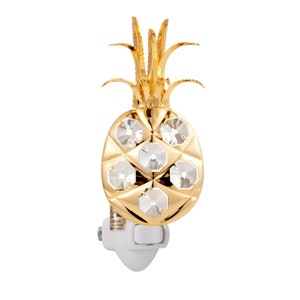 May include: A gold pineapple-shaped night light with clear crystal accents. The night light plugs into a standard outlet.
