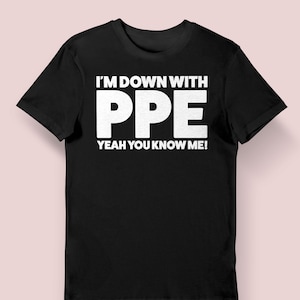 May include: Black t-shirt with the text "I'M DOWN WITH PPE YEAH YOU KNOW ME!" in bold white letters. The shirt has short sleeves and a crew neck. The background is a solid light pink.