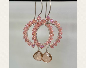 May include: A pair of silver earrings with pink crystal beads and teardrop-shaped pink crystal pendants.