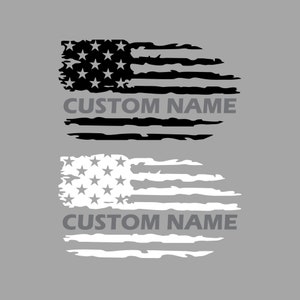 May include: Two distressed American flag decals, one in black and one in white, each featuring a field of stars and horizontal stripes with a weathered, torn appearance. The text CUSTOM NAME is printed in a bold, sans-serif font across each flag.