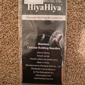 May include: A close-up of a HiyaHiya Bamboo Circular Knitting Needle set in a black and white packaging. The needles are 9 inches long and 3.75 mm in diameter. The packaging includes the brand name HiyaHiya and the text "Designer Knitting Accessories".