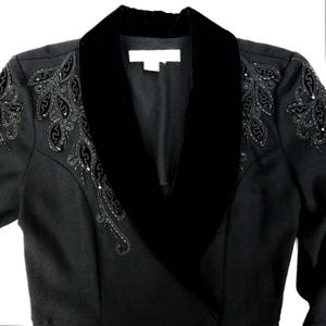 Puede incluir: Una chaqueta negra con cuello de terciopelo y bordados de cuentas en los hombros.