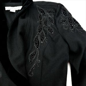 Puede incluir: Blazer negro con cuello de terciopelo y bordado floral con cuentas en el hombro.