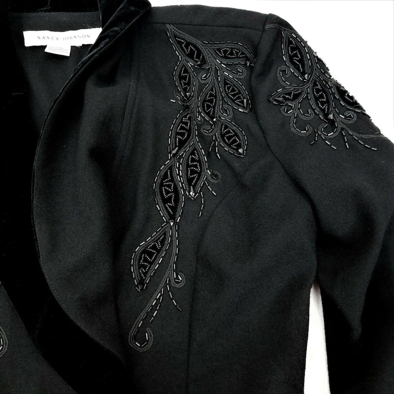 Puede incluir: Blazer negro con cuello de terciopelo y bordado floral con cuentas en el hombro.