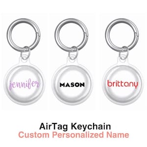 May include: Three silver AirTag keychains with clear plastic covers. The covers have personalised names: "jennifer" in purple, "MASON" in black, and "brittany" in red.