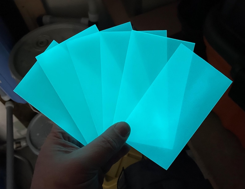 Puede incluir: Cinco l&aacute;minas de pl&aacute;stico acr&iacute;lico transl&uacute;cido azul turquesa. Las l&aacute;minas est&aacute;n apiladas una encima de la otra y brillan en la oscuridad.