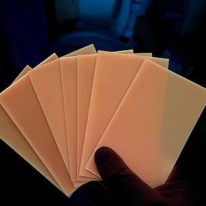 K&ouml;nnte beinhalten: Ein Stapel aus acht d&uuml;nnen, pfirsichfarbenen Bl&auml;ttern Papier.