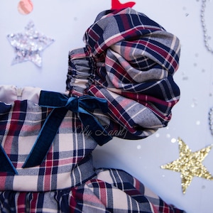 May include: A plaid dress with a blue velvet bow and puffed sleeves. The dress is made of a soft, comfortable fabric and has a festive feel.
