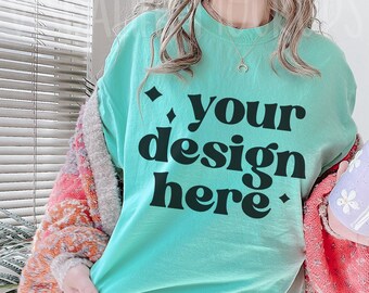 May include: A turquoise blue t-shirt with the text "your design here" in black.