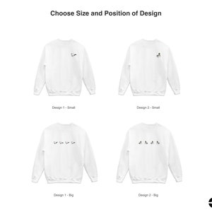 May include: Four white sweatshirts with different designs. The top two sweatshirts have a single design, while the bottom two sweatshirts have a row of five designs. The text "Choose Size and Position of Design" is at the top of the image.