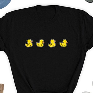 May include: Black t-shirt with a line of four yellow rubber duckies printed on the front.