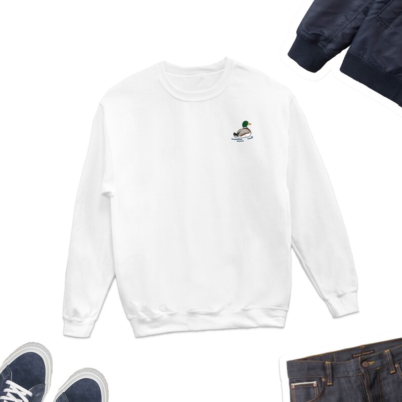 May include: White long-sleeved sweatshirt with a small embroidered image of a duck on the left chest.