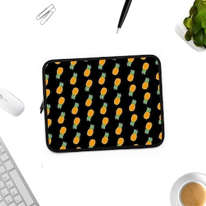 May include: Black laptop sleeve with a repeating pattern of yellow pineapples on a black background.
